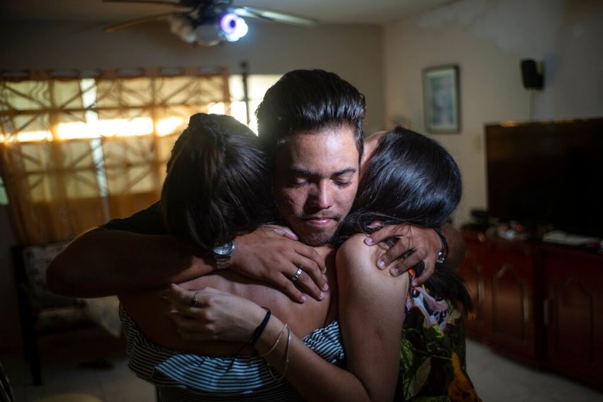 Marcos Marzo abraza a sus amigas que vinieron a despedirse de él, en La Habana, el miércoles 25 de enero de 2023, luego de enterarse que había recibido un permiso para viajar a Estados Unidos.
