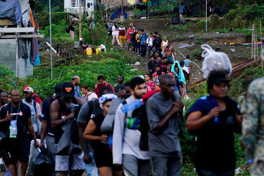 Migrantes en su ruta hacia el norte hacen fila para tomar un bote a motor, en Bajo Chiquito, en la provincia de Darién, Panamá,