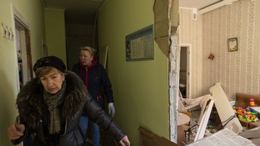 Dos mujeres recorren el interior de una escuela dañada, junto a otros edificios residenciales, en un bombardeo, en Kiev, Ucrania, el 18 de marzo de 2022.&nbsp;