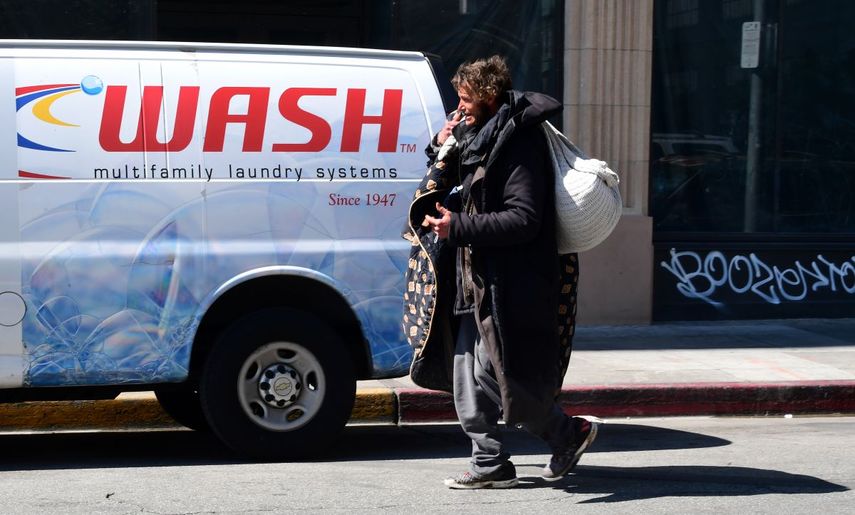 Un hombre sin hogar carga sus pertenencias mientras camina por una calle en Los &Aacute;ngeles, California, el 18 de marzo de 2020. La epidemia de coronavirus representa una nueva amenaza para las poblaciones sin hogar en las ciudades de los Estados Unidos.