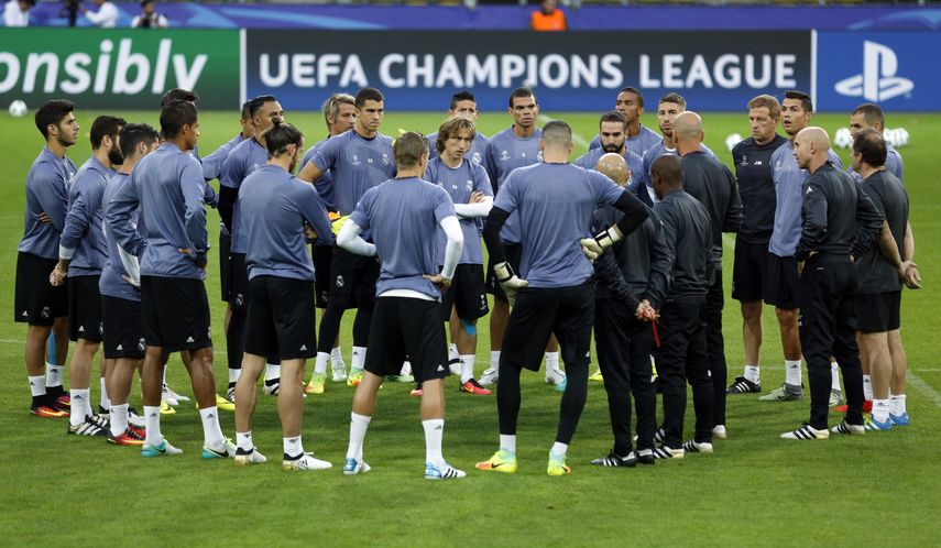 Jugadores del&nbsp;Real&nbsp;Madrid&nbsp;se reúnen para escuchar a su entrenador, el francés Zinedine Zidane (sexto de izquierda a derecha), durante el entrenamiento de este lunes