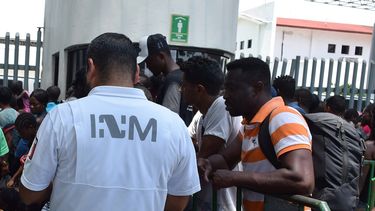 Un funcionario del Instituto Nacional de Migración dialoga con migrantes, muchos de ellos cubanos, en las afueras de una estación migratoria en el municipio de Tapachula, en el estado de Chiapas, México.