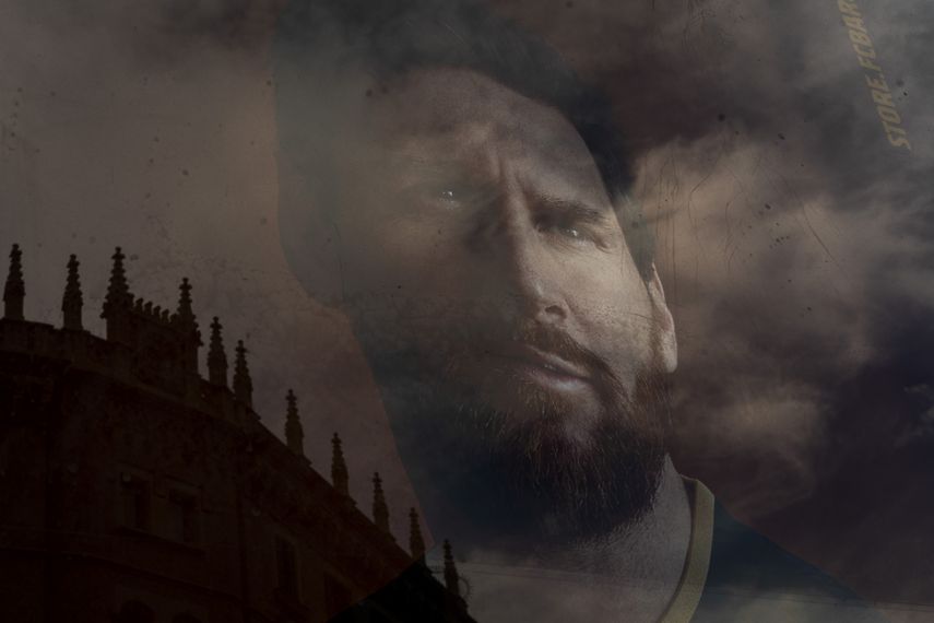La imagen del astro del Barcelona Lionel Messi se refleja en la ventana de una tienda del club enBarcelona, el martes 1 de septiembre de 2020