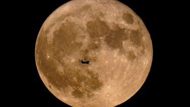 Un avión pasa frente a una superluna, el 13 de julio de 2022, en Milwaukee.&nbsp;