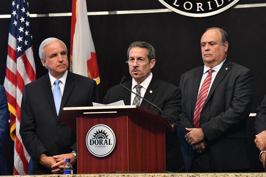 Hace uso de la palabra el comisionado condal José Pepe Díaz, y escuchan el alcalde de Miami-Dade Carlos Giménez (izq.) y su homólogo de Doral Juan Carlos Bermúdez.