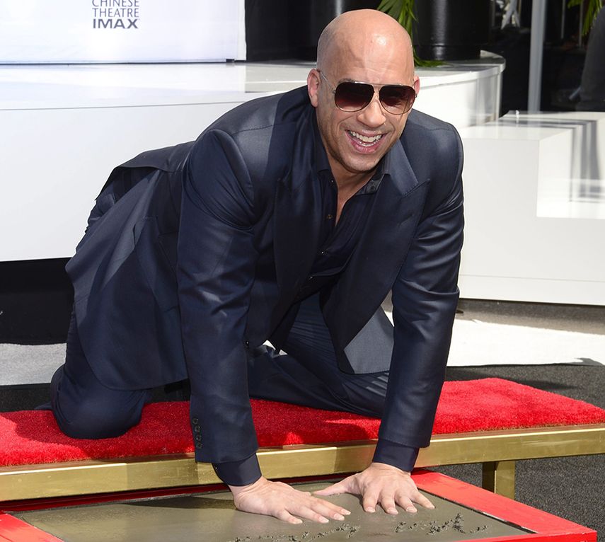 El actor estadounidense Vin Diesel plasma sus huellas durante una ceremonia su honor el 1 de abril de 2015. (EFE)