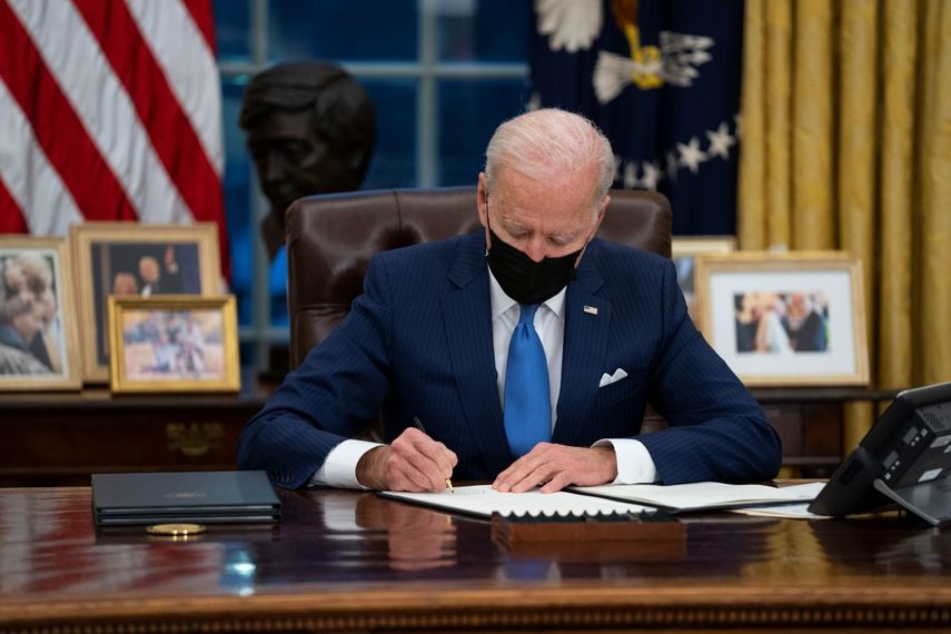 El presidente Joe Biden firma una orden ejecutiva en materia migratoria, en la Oficina Oval de la Casa Blanca, el martes 2 de febrero de 2021, en Washington.