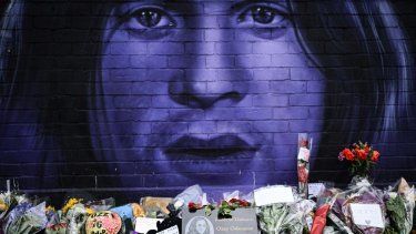 Una fotografía tomada el 23 de julio de 2025 muestra flores, velas y dibujos depositados en un monumento improvisado junto a un mural que representa al fallecido cantautor británico Ozzy Osbourne, en Birmingham, centro de Inglaterra, un día después de su muerte. &nbsp;
