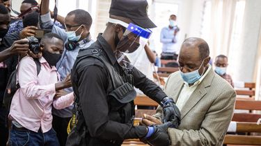 En esta foto de archivo tomada el 14 de septiembre de 2020, el héroe del Hotel Rwanda, Paul Rusesabagina (derecha), es esposado por un oficial de policía después de su sesión de la corte preliminar en el tribunal primario de Kicukiro en Kigali, Ruanda. Paul Rusesabagina, el héroe del Hotel Rwanda que se convirtió en un feroz crítico del gobierno, fue declarado culpable el 20 de septiembre de 2021 por cargos de terrorismo después de lo que sus partidarios dicen que fue un juicio por motivos políticos. &nbsp;
