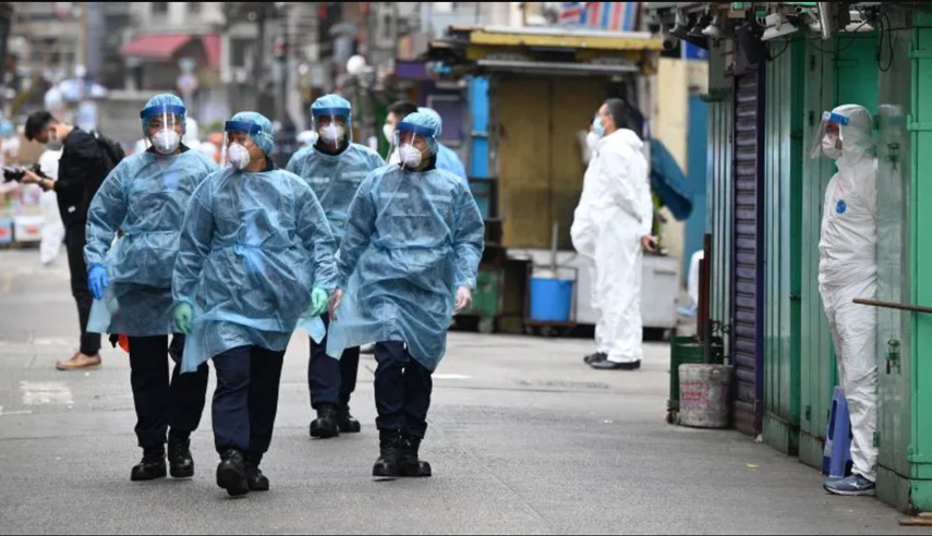 La policía patrulla las calles con equipo de protección mientras las autoridades continúan realizando pruebas por segundo día en el área de Jordania en Hong Kong el 24 de enero de 2021, luego de que miles de personas recibieron la orden de permanecer en sus hogares para el primer cierre de COVID-19 de la ciudad mientras las autoridades luchan un brote en uno de sus distritos más pobres y densamente poblados.