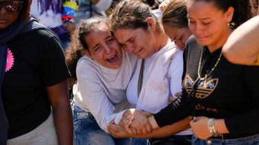 Una hermana del minero Santiago Mora, a la izquierda, llora con otros familiares mientras lo entierran en el cementerio de La Paragua, estado Bolívar, Venezuela.