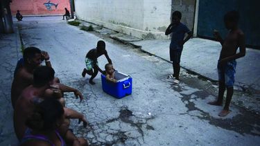 Un niño empuja a otro que está sentado dentro de una hielera en una calle del barrio Jaimanitas en La Habana, Cuba.