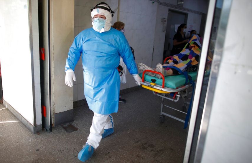 Un médico traslada a un paciente con COVID-19 a una ambulancia para ser transferido a otro hospital en Avellaneda, Argentina.&nbsp;