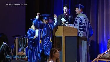 William Maillis, el niño de 11 años que acaba de alcanzar un título de College en St. Petersburg, Florida, levanta las manos en señal de triunfo durante la ceremonia de graduación.