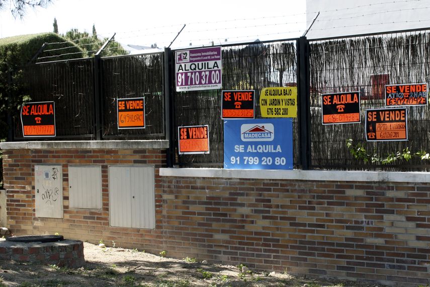 Carteles de distintas inmobiliarias alquilando o vendiendo propiedades en España.