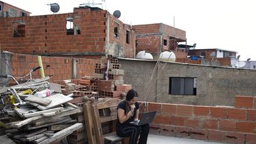Maria Figueroa se conecta a la internet en el techo de su casa para enviar a la escuela las tareas de su hijo el 6 de mayo del 2020 en el barrio Catia de Caracas. La vivienda llevaba dos semanas sin agua corriente.