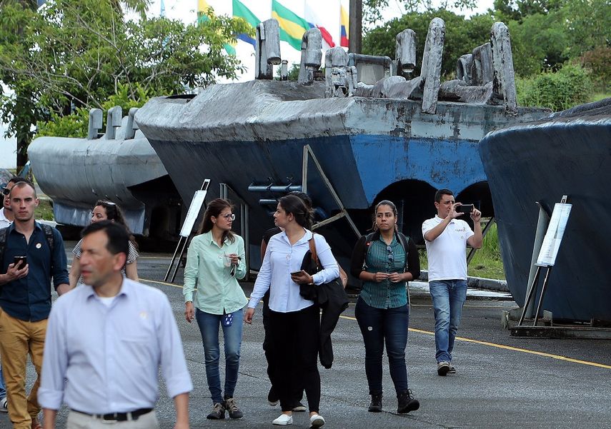 Integrantes de la Armada colombiana caminan frente a semisumergibles utilizados para transportar droga y decomisados en el Pacífico hace seis días, en la base naval de Bahía Málaga (Colombia).