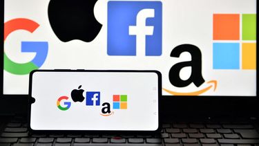 Logotipos de Google, Apple, Facebook, Amazon y Microsoft muestran en un teléfono móvil y una pantalla de ordenador portátil.