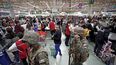 La policía militar hace guardia en un supermercado mientras los clientes pagan por sus compras, en Santiago, Chile, el lunes 21 de octubre de 2019.