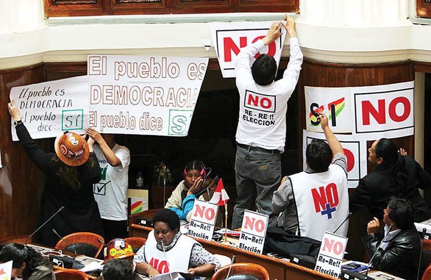 Legisladores opositores usan camisetas blancas  y llevan carteles con el lema “No a la reelección” en el Congreso en La Paz, controlado por el oficialismo. (EFE)