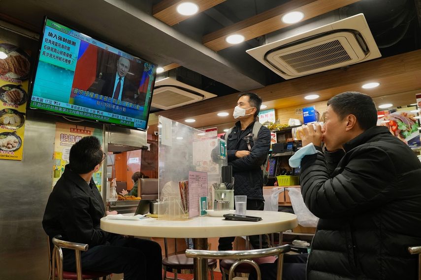 Tres personas observan un programa de televisión que transmite la noticia del ataque ruso a Ucrania, en un restaurante en Hong Kong, el 24 de febrero de 2022.&nbsp;