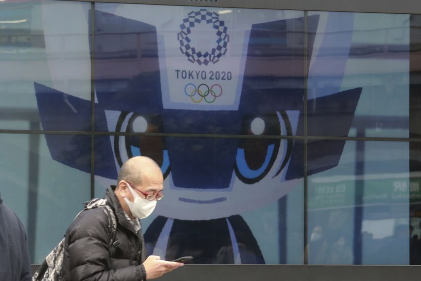 Un hombre camina frente a una pantalla donde se publicitan los Juegos Olímpicos en Tokio, el miércoles 27 de enero de 2021&nbsp;