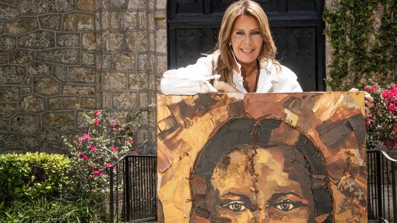 La artistas venezolana Verónica Cruz Luna posa junto a una de las piezas de la muestra de arte Sagrado