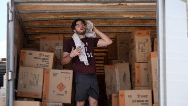Ethan Hickman utiliza una toalla para enjugarse el sudor mientras se toma un descanso de descargar un contenedor bajo un calor sofocante ante Powder Monkey Fireworks, antes de la apertura de un puesto el lunes 17 de junio de 2024, en Weldon Spring, Missouri, Estados Unidos.&nbsp; 