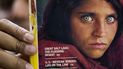 En imagen de archivo del 26 de octubre de 2016, el paquistaní Inam Khan, dueño de una librería, muestra una copia de una revista de National Geographic con la fotografía de la mujer afgana Sharbat Gulla, en Islamabad, Pakistán. En imagen de archivo del 26 de octubre de 2016, el paquistaní Inam Khan, dueño de una librería, muestra una copia de una revista de National Geographic con la fotografía de la mujer afgana Sharbat Gulla, en Islamabad, Pakistán.