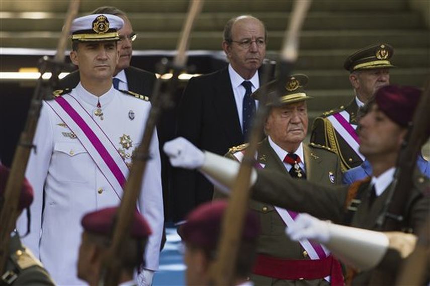 El príncipe Felipe (izquierda), heredero de la corona de España, y el rey Juan Carlos (derecha), pasan revista durante una marcha militar por el Día de las Fuerzas Armadas el domingo 8 de junio de 2014 en Madrid. (Foto AP/Andres Kudacki)