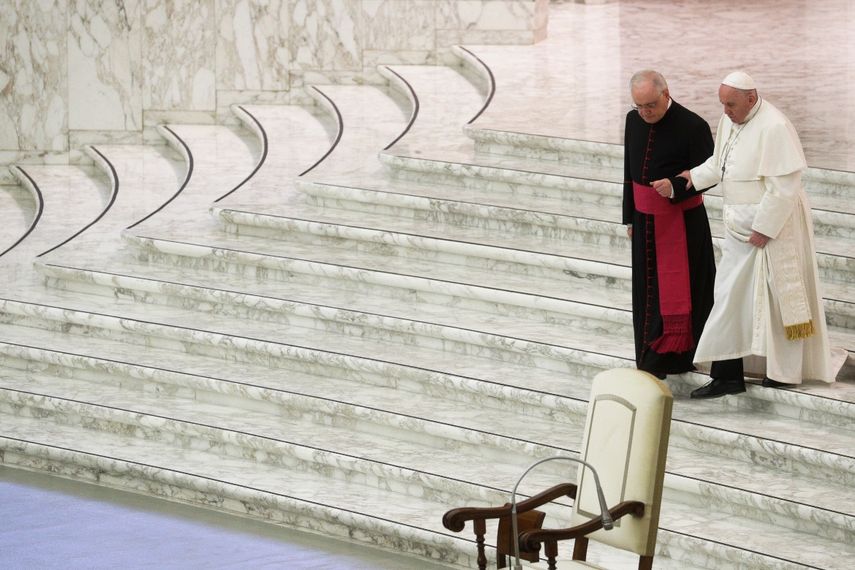 En esta imagen de archivo, tomada el 21 de diciembre de 2020, el papa Francisco recibe ayuda de monseñor Leoardo Sapienza para bajar las escaleras durante un saludo de Navidad con empleados del Vaticano, en el salón Pablo VI, en el Vaticano