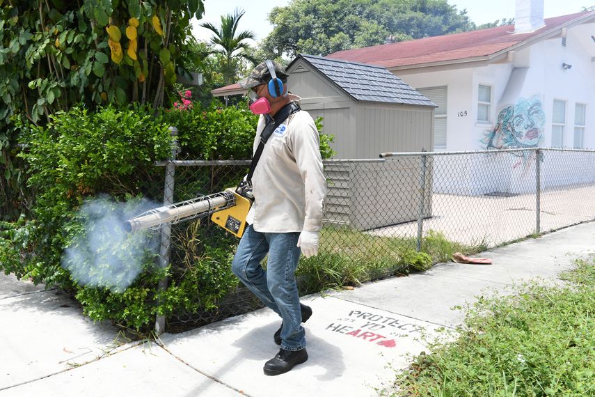 Un técnico en fumigación realiza su faena en una calle de Miami.