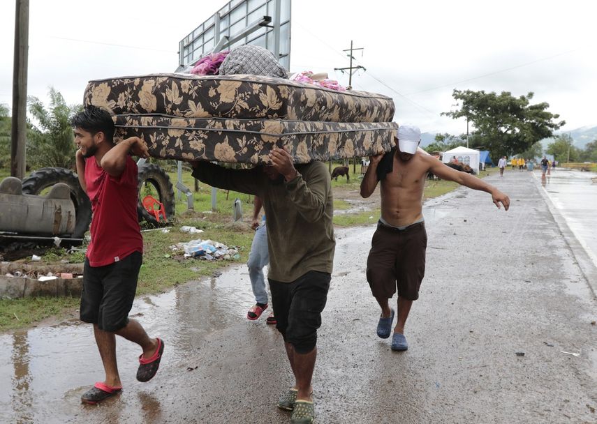 Vecinos se ayudan a transportar algunas pertenencias el lunes 16 de noviembre de 2020 para abandonar la zona donde se espera que toque tierra el huracán Iota, en San Manuel Cortés, Honduras.&nbsp;