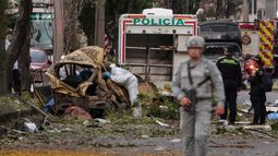 Un agente de policía en Colombia inspecciona los restos de un vehículo en el lugar donde explotó una bomba en Cali, Colombia, el 21 de agosto de 2025, en otro hecho de violencia. Cinco personas murieron y decenas resultaron heridas. &nbsp;