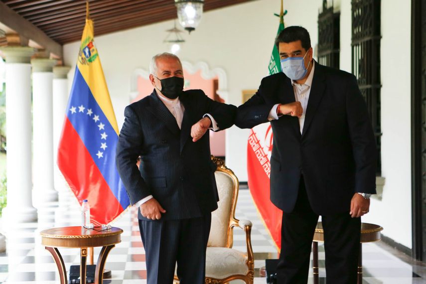 Imagen del folleto publicado por la presidencia venezolana que muestra al presidente de Venezuela, Nicolás Maduro (derecha) chocando con el ministro de Relaciones Exteriores de la República Islámica de Irán, Javad Zarif (izquierda) en el Palacio de Miraflores en Caracas, el 5 de noviembre de 2020. Zarif dijo el jueves que su país estará del lado de Venezuela ante las sanciones de Estados Unidos contra ambos países.