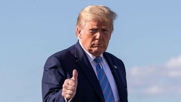 El presidente Donald Trump levanta el pulgar mientras camina por la pista para abordar el avi&oacute;n presidencial.