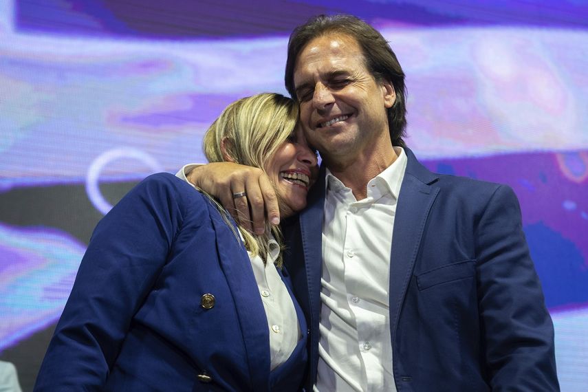 Luis Lacalle Pou, candidato presidencial del Partido Nacional, a la derecha, abraza a su compa&ntilde;era de f&oacute;rmula Beatriz Argimon mientras se presentan ante los partidarios al final del d&iacute;a de las elecciones en Montevideo, Uruguay, el domingo 27 de octubre de 2019.