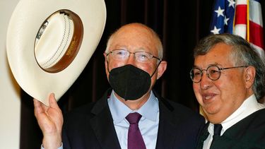 Ken Salazar (izquierda) saluda con el sombrero luego de prestar juramento como el embajador de Estados Unidos en México, el jueves 26 de agosto de 2021, en Denver.