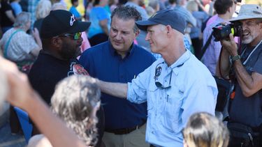 Rick Scott, gobernador de la Florida, conversa con residentes de St. Andrews en Panama City, donde evalúa los daños ocasionados por el paso del huracán Michael.