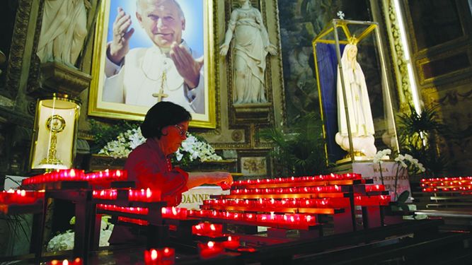 Una feligresa visita una iglesia en Roma el jueves. El Vaticano da los toques finales a la ceremonia de canonización de Juan XXIII y Juan Pablo II el domingo. (AP)