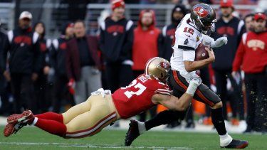 Tom Brady, quarterback de los Buccaneers de Tampa Bay, acarrea el balón frente a Nick Bosa, de los 49ers de San Francisco, en el partido del domingo 11 de diciembre de 2022.