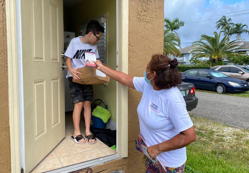 Una voluntaria entrega una de las cajas con alimentos.