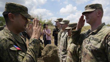 El comandante militar filipino Anthony Coronel (i) frente a soldados estadounidenses en la provincia Nueva Ecija, en el norte de Filipinas, el 31 de marzo de 2023.&nbsp;