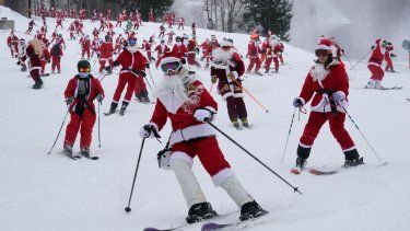 Personas disfrazadas de Santa Claus esquian en un evento caritativo en Sunday River Ski Resort, en Newry, Maine, el 11 de diciembre de 2022.&nbsp; &nbsp;