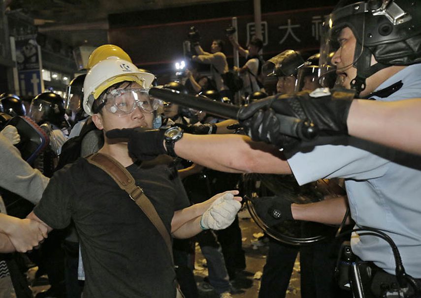 Varios policías discuten con manifestantes en un área ocupada del distrito Mong Kok de Hong Kong, el miércoles 26 de noviembre de 2014 en la madrugada. (AP)