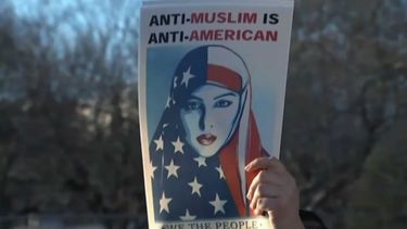 Una mujer levanta un cartel de protesta contra las medidas de Trump hacia los inmigrantes y refugiados de países musulmanes.