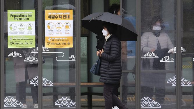 Una mujer con mascarilla pasa junto a carteles sobre precauciones contra el neuvo coronavirus en una estaci&oacute;n de autob&uacute;s en Se&uacute;l, Corea del Sur, el martes 25 de febrero de 2020.&nbsp;