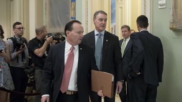 El senador republicano de Utah Mike Lee (c-i) y el de Georgia, David Perdue (c-d), salen de la cámara del Senado en el Capitolio en Washington, donde los republicanos publicaron un borrador de su proyecto de ley de&nbsp;salud&nbsp;que reemplazaría a la Affordable Care Act (Ley del Cuidado Asequible de&nbsp;Salud) promovida por la administración Obama.