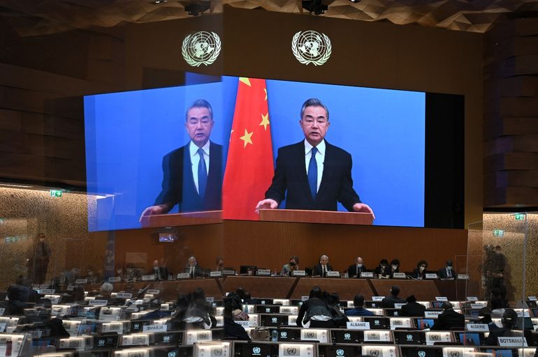 El ministro de Relaciones Exteriores de China, Wang Yi, aparece en una pantalla mientras pronuncia un discurso remoto en la apertura de una sesión del Consejo de Derechos Humanos de la ONU, luego de la invasión rusa en Ucrania