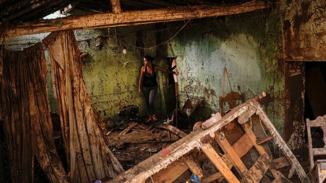 Erika Quintero observa de pie dentro de su casa que resultó dañada después de un deslizamiento de tierra e inundaciones que arrasaron Las Tejerías en Venezuela, el lunes 10 de octubre de 2022